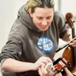 Music tutor helping a pupil learn the violin